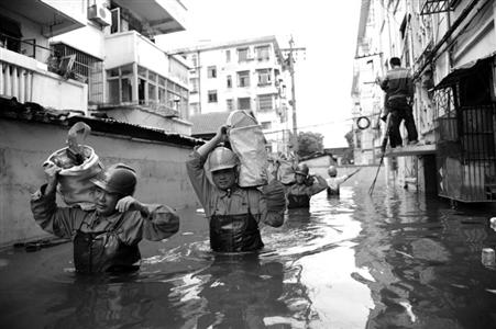 10月11日，在余姚市积水较深的花园新村小区，电力工人运送抢修设备。　新华社发
