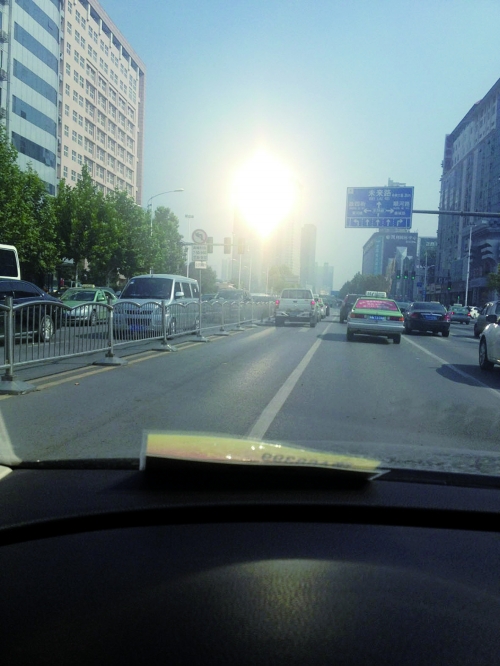 市民驾车在金水路上由西向东行驶中,被反光的玻璃幕墙“闪”到眼