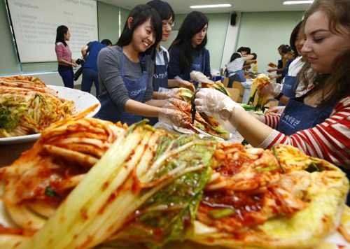 图片为活动现场成均馆大学的留学学生们学习制作泡菜。（韩联社）