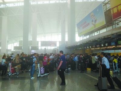 广州白云机场一卖场出现明火，导致整个出发大厅烟雾弥漫。汤凯锋 摄