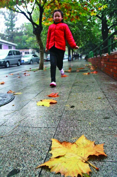 雨后,一个小姑娘在马路上欢快地跑过. 见习记者 樊蓉