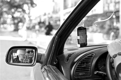 固定在出租车上装有打车软件的手机。目前大部分出租车司机均使用非官方版本打车软件。 新京报记者 周岗峰 摄