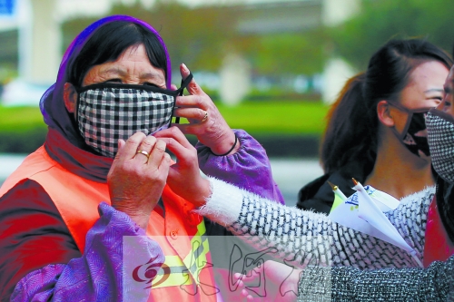 “炯炯族”为环卫工人赠送口罩。