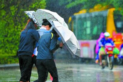 海口风雨大作,海口市民顶风冒雨前行