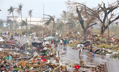 图为当地时间11月10日,菲律宾塔克洛班市,民众在灾后废墟中行走.