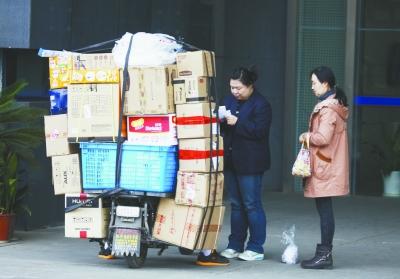 昨天,快递员在河西一家写字楼门口分发快递.本报记者 崔晓 冯芃摄