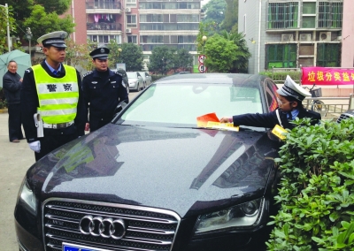 为督促车辆有序停放，南京五大队交警和龙江小学“小交警”给小区车辆发“电话联系卡”。 郭一鹏 摄