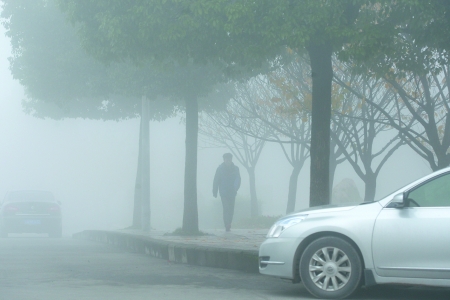 昨日,重庆邮电大学,市民走过大雾弥漫的校园.记者 唐浩 摄