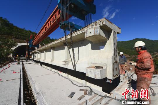 图为架梁机吊装纵移t型梁. 汪建云 摄