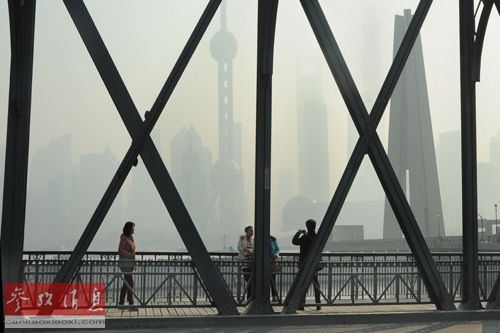 资料图片：2013年12月2日上午，游客在上海外滩苏州河口的外白渡桥上游览，远处陆家嘴的高楼被笼罩在雾霾中。新华社发（朱岚 摄）