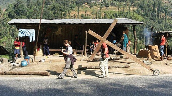 哈蒙带着十字架行走在尼泊尔一处村庄。