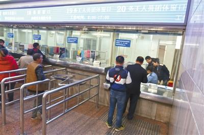 　昨日，北京西站，两位企业负责人在给员工办理春运团体票手续。新京报记者 浦峰 摄