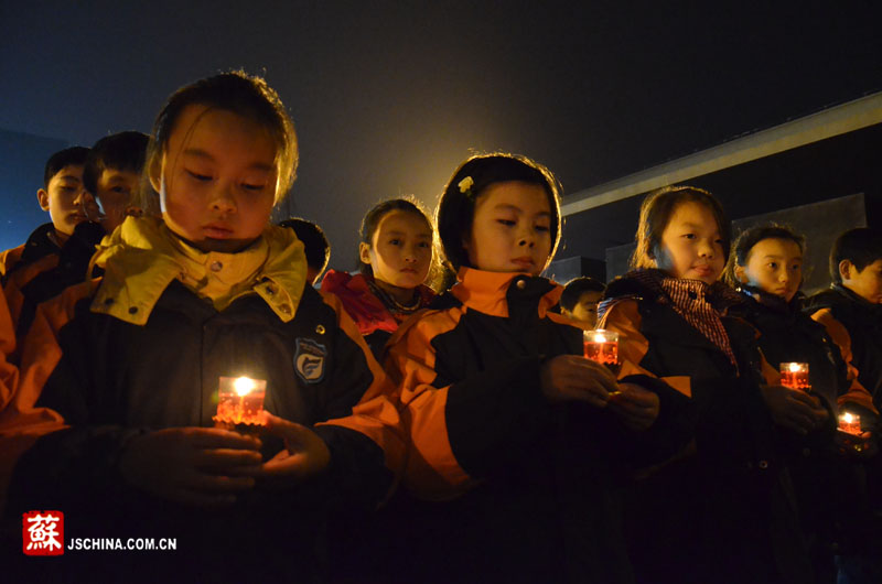 小学生手捧红烛祭奠遇难同胞.