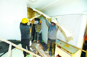 今天上午8时许，工人将位于方庄芳城园一区一单元房内的群租房隔断拆除。 记者刘平摄