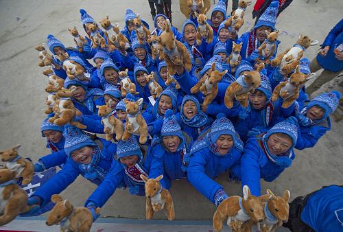 12月23日,重庆市奉节县石罐小学,孩子们兴高采烈地展示换上的新衣服.