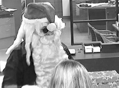 23日，视频截图显示，一名扮成圣诞老人的男子来到银行抢劫。