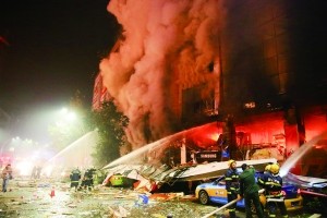 12月26日，消防人员在泸州市摩尔玛商场天然气爆燃事故现场灭火。新华社发