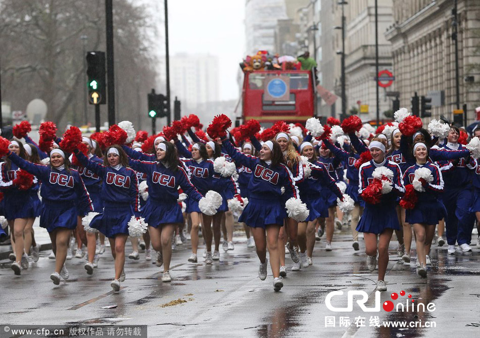 当地时间2014年1月1日,英国伦敦新年大游行开幕,啦啦队员们披着雨衣在