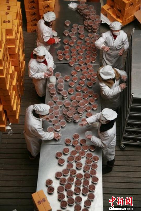 图为杭州灵隐寺的义工们在包装腊八粥。 李晨韵 摄