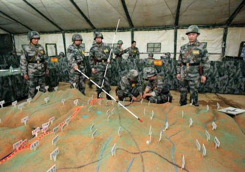 资料图:解放军指战员正在利用沙盘进行战争推演.