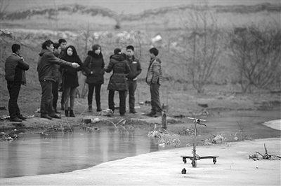 昨日，一个儿童滑板车被丢弃在顺义西大坨村的水塘冰面上。1月4日，住在水塘十几米外的八岁男童陈风云救落水小伙伴时溺亡。本版摄影 新京报记者 吴江