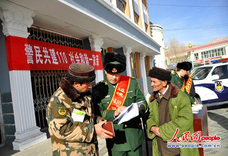新疆喀什边防支队民警正在为塔吉克族农牧民发放"边境110"宣传图册