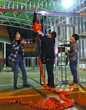 23时50分 整个火车站关门之前,工作人员在出口处准备燃放鞭炮纪念这不平凡的日子。