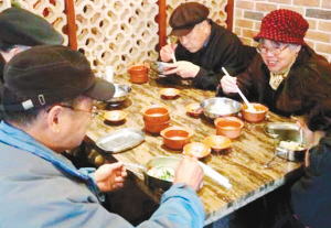 老人们围在老年餐桌前吃饭,聊天