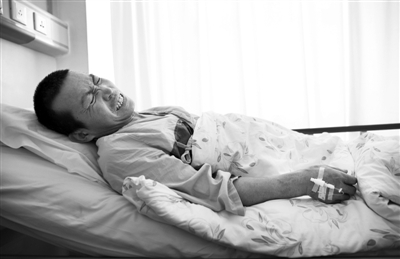 2014年1月21日，北京友谊医院。血栓复发的郑艳良躺在病床上，等待身体检测以及相应的治疗。稍微动一下臀部，血栓处便痛得他面部抽搐。新京报记者 尹亚飞 摄