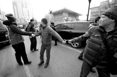 便衣民警给一个号贩子戴上手铐.京华时报记者欧阳晓菲摄