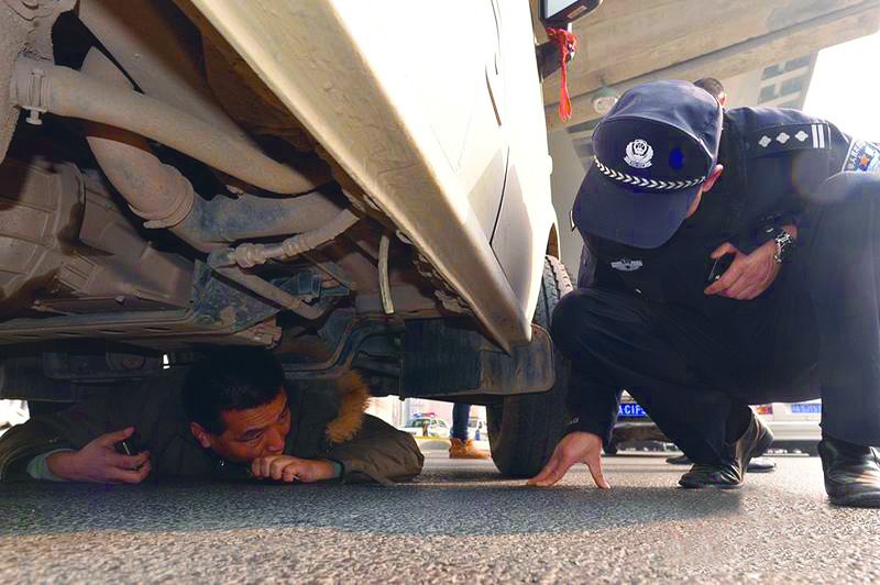 市清江中路路口出现了暂时拥堵的情况,一名男子趴在面包车底时间长达