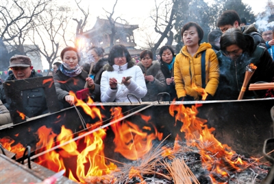 1月31日，雍和宫，几位香客在香炉前点香。昨日全天共有7.6万人到雍和宫上香，比去年同期增加5000多人。