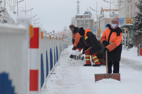 2月2日,在内蒙古牙克石市,环卫工人在风雪中清理积雪.