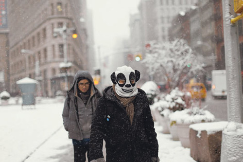 纽约市昨天白天降雪未停，降雪量至少15公分，图为行人走在覆雪的街头，其中1名戴着猫熊头套。欧新社