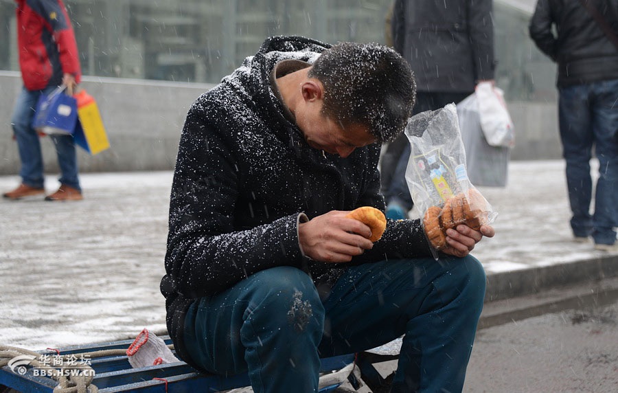 农民工西安火车站冒雪谋生 网友感动叹生活不易