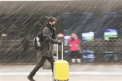 图3为山东青岛火车站站前广场,一名小朋友被家长抱着在雪中前行.