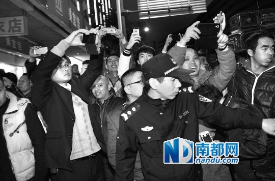 2月9日晚9时，东莞莞城国安酒店，群众围观警方扫黄行动。南都记者 方光明 摄