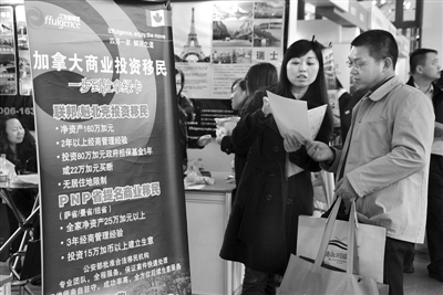 2012年3月18日，上海之春房展会海外置业展区现场，参展方向顾客推销加拿大商业投资移民项目。