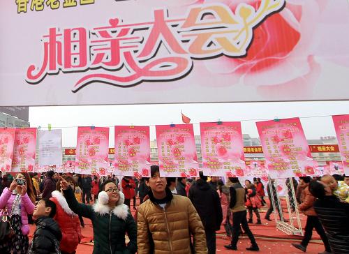 2月15日,男女青年在河南省温县举行的相亲大会活动现场阅读相亲资料.