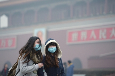 昨天,两名游客走过雾霾笼罩中的天安门。京华时报记者谭青摄