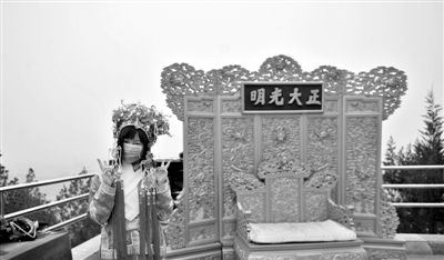 昨日,一名游客在北京景山公园内戴口罩着古装拍照。京城重污染5天无缓解。新华社发