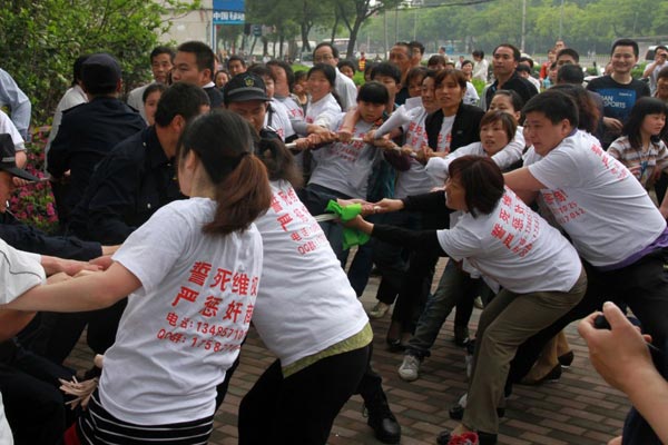 业主与保安因拉扯警戒线而进行"拔河比赛"