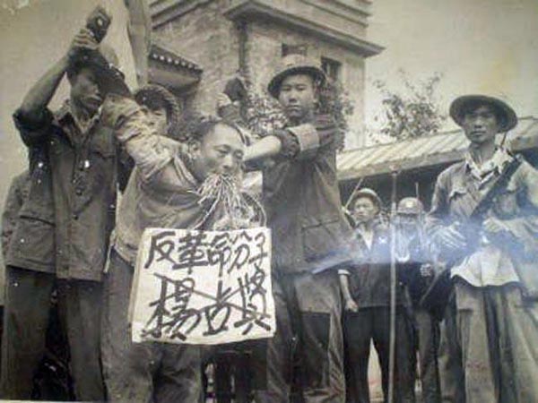 图为文革中被批斗的"反革命分子",他的嘴里还被塞上了草.