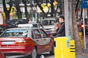 市民在路边用手机软件打出租车.