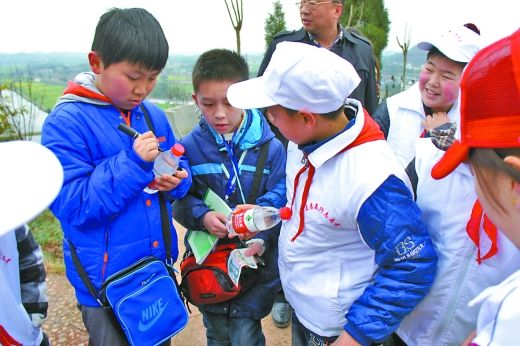 小记者陈柏羽（左一）在崇龛景区里花钱买了两瓶矿泉水，准备奖励给捡拾垃圾的游客。