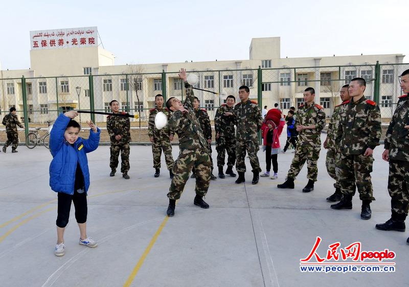 图为杂技"小师傅"在给武警官兵一同转布卷; 新疆边防机动部队:执勤