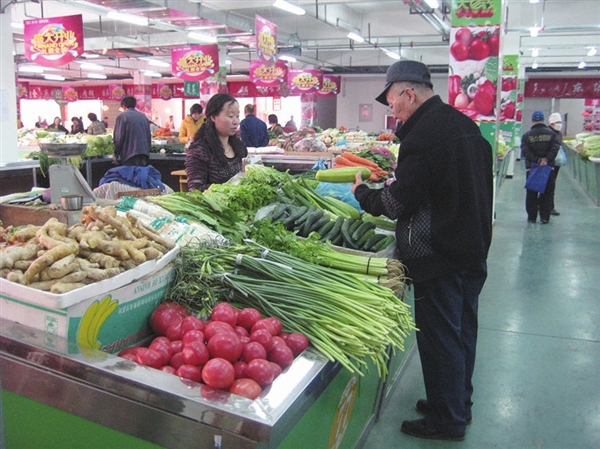 市民在菜市场买菜,拿起哪种菜问询
