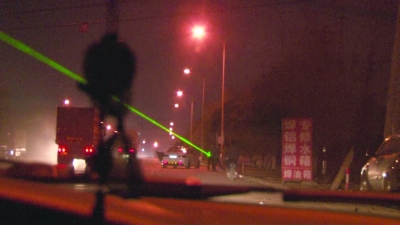 在南京江宁天元东路和万安东路，一些商贩正将激光笔对着路面“扫射”。