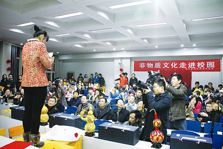 农家女郑平(右一)在山西师范大学美术学院表演蒙眼剪纸绝技.