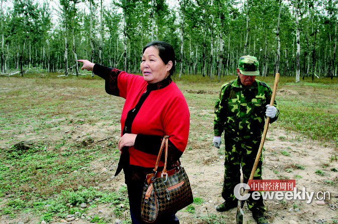 刘玉英，身后是她雇来看护林地的工人 《中国经济周刊》记者 肖翊|摄